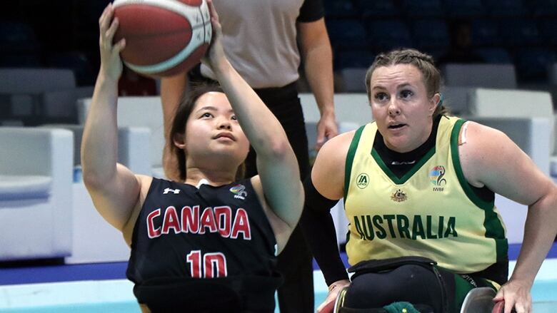 Women's athlete attempts to make a shot under the basket at wheelchair basketball world championships.