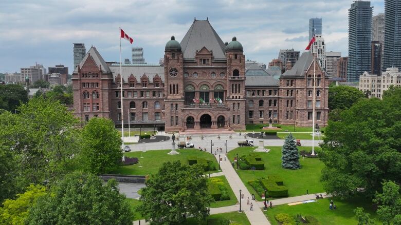 Queen's Park seen from the air, with lush trees and grass out front.