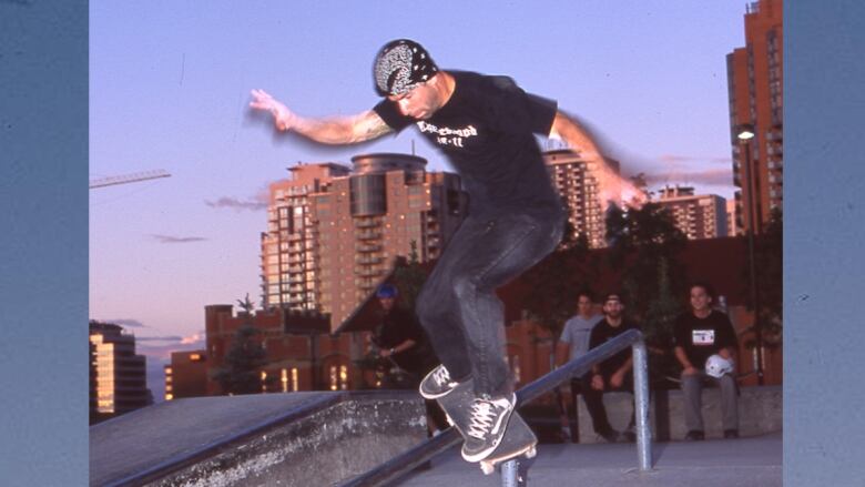 A man on a skateboard balances on top of a steel rail.