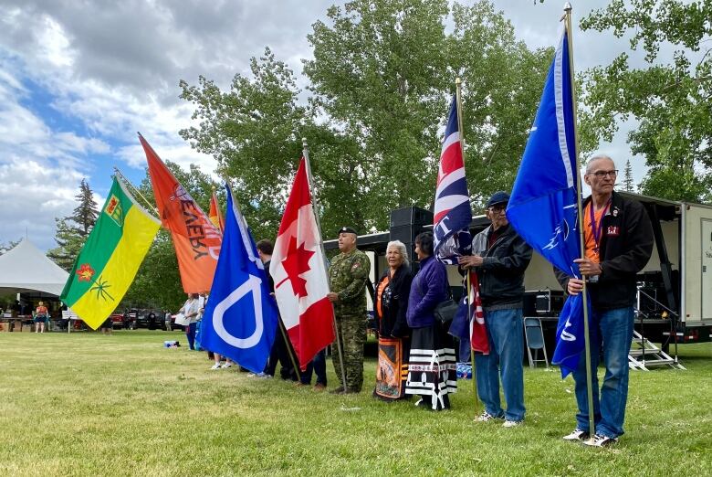 A lineup of people holding flags.