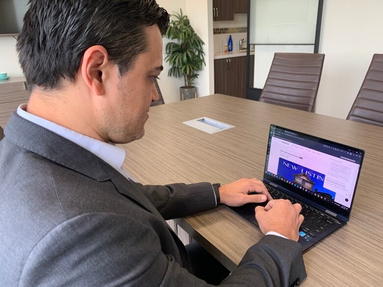 A man types on a laptop.