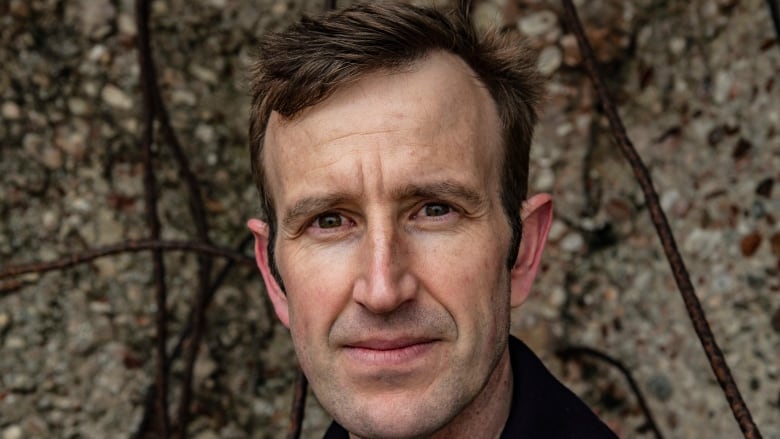 A close-up photo of a man with short brown hair.