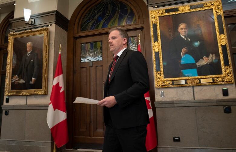 Government House Leader Mark Holland makes his way to a microphone to speak with reporters in the Foyer of the House of Commons.