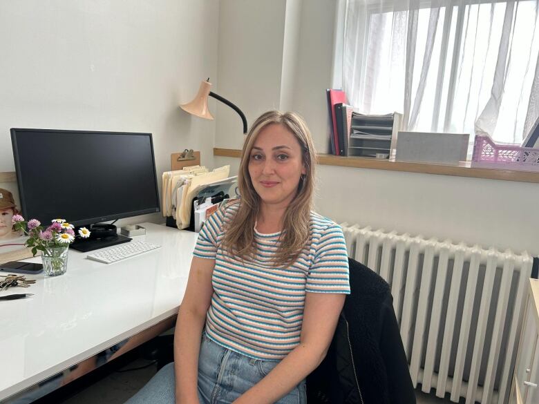 A woman sits in her office. 