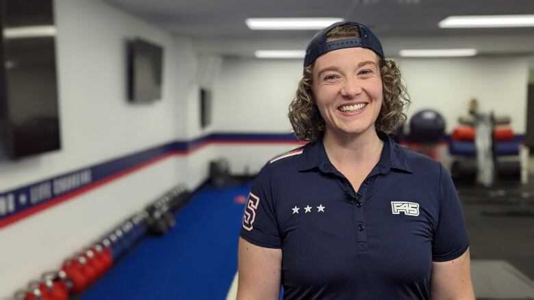 Kate is shown smiling with gym equipment in the background.