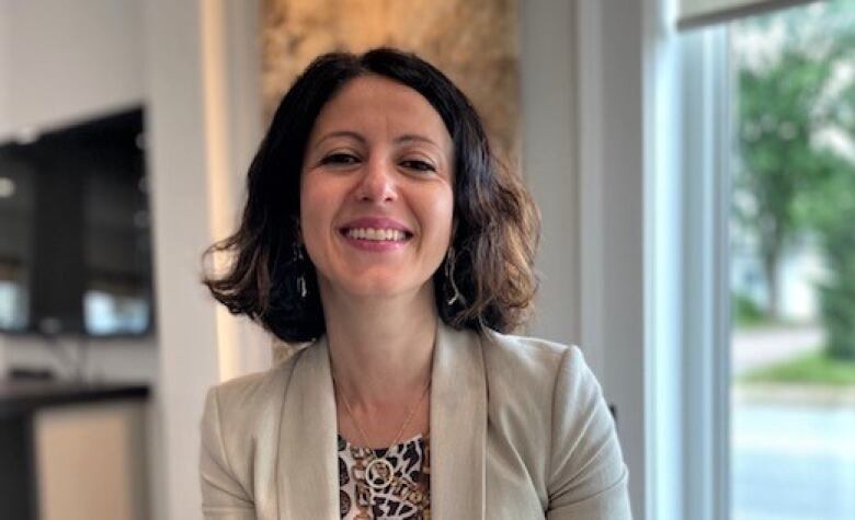 A smiling woman inside a home.