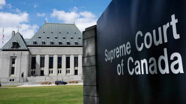 A sign for the Supreme Court of Canada is seen in front of the lawn of the courthouse in Ottawa.