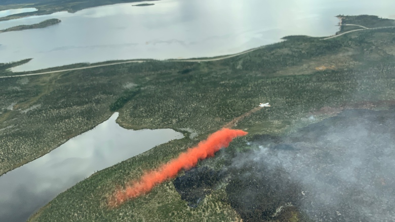 A water bomber drops fire retardant just north of Wekweeti. The retardant is one of the measures firefighters use to protect the community.