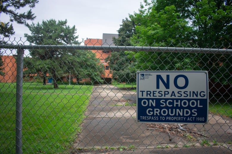 A no trespassing sign in front of a school building.