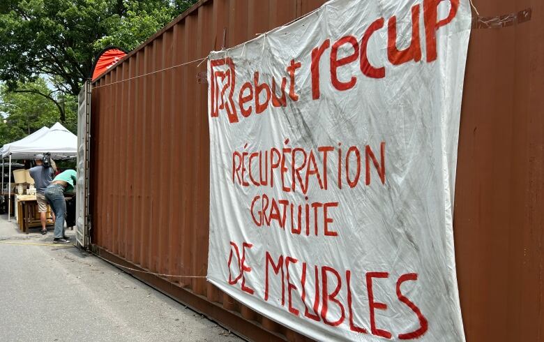 A shipping container with a painted banner that says RebutRcup Rcupration gratuite de meubles. 