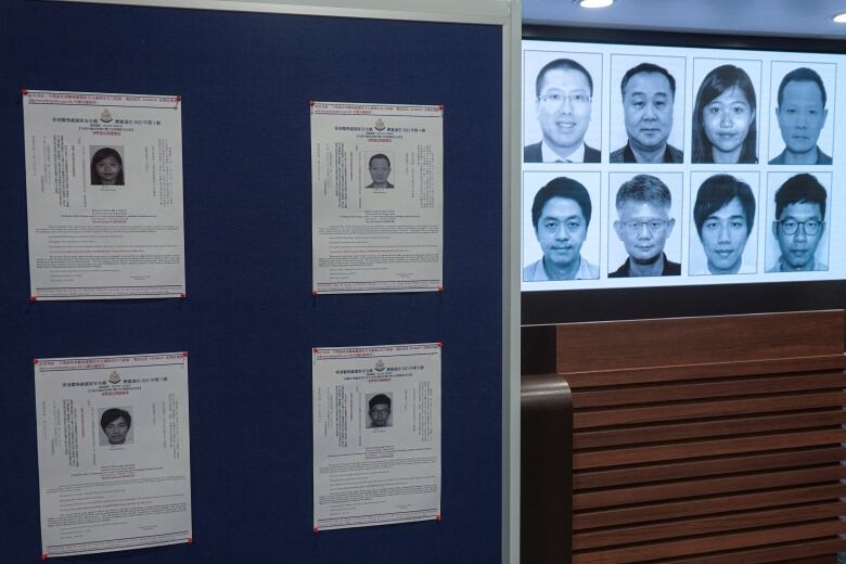 A video screen shows headshots of eight individuals inside a room. 