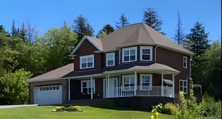 A home is shown on a rural tree-lined property before it was destroyed by a wildfire.