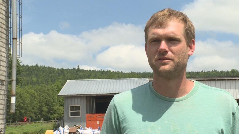 A man standing in front of a farm.