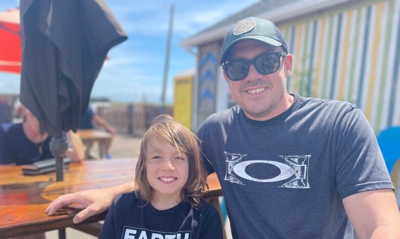 Ken Simpson and his son smile on a sunny day.