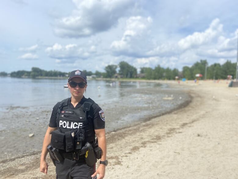 Ottawa police officer stands on beach. 