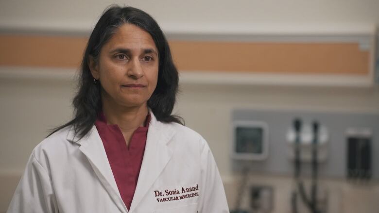 A doctor stands in a clinic room