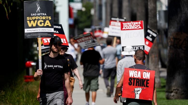 A sign reads 'SAG-AFTRA Supports WGA' as SAG-AFTRA members walk the picket line in solidarity with striking WGA (Writers Guild of America) workers outside Netflix offices on July 11, 2023 in Los Angeles, California. SAG-AFTRA and top studios and streamers have agreed to extend their current contract negotiations until July 12 at 11:59 p.m. 