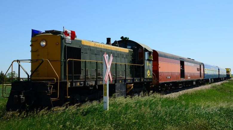 A train on a railroad track at Aspen Crossing.