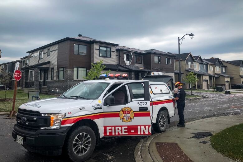 Fire crews are pictured on a street after at least one tornado has hit the community of Barrhaven, about 20 kilometres south of the city core in Ottawa, Ontario on Thursday, July 13, 2023. 