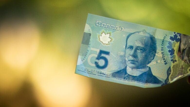 A Canadian five dollar bill bank note is pictured.