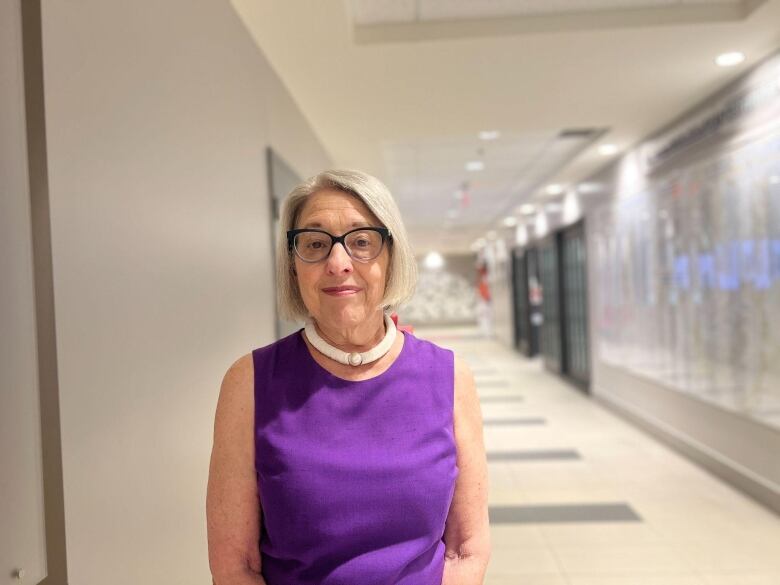 A woman stands in a hall.