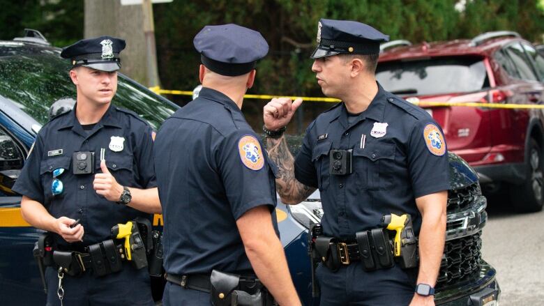 Police officer stand guard near a police vehicle.