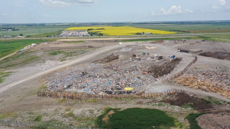 An aerial photo shows waste at a landfill surrounded by farm fields.