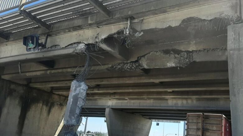 The smashed-up underside of a highway overpass is shown in close-up.