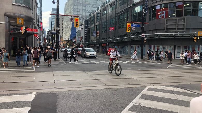 Cyclists cross early at Yonge and Dundas streets in Toronto July 18, 2023