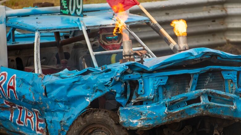 A man drives a derby car that shoots flames.