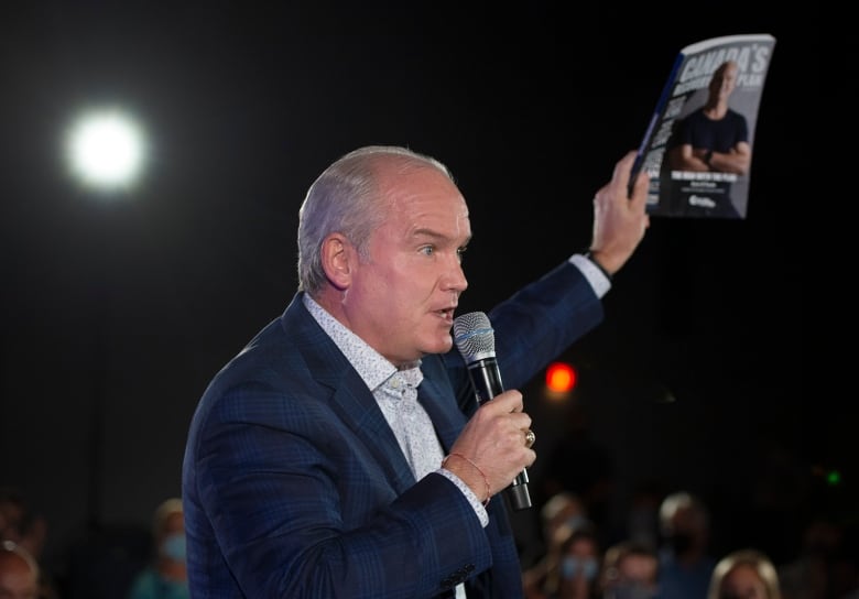 Former Conservative Leader Erin O'Toole holds up his platform book