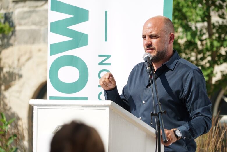 A man speaking to a crowd. 