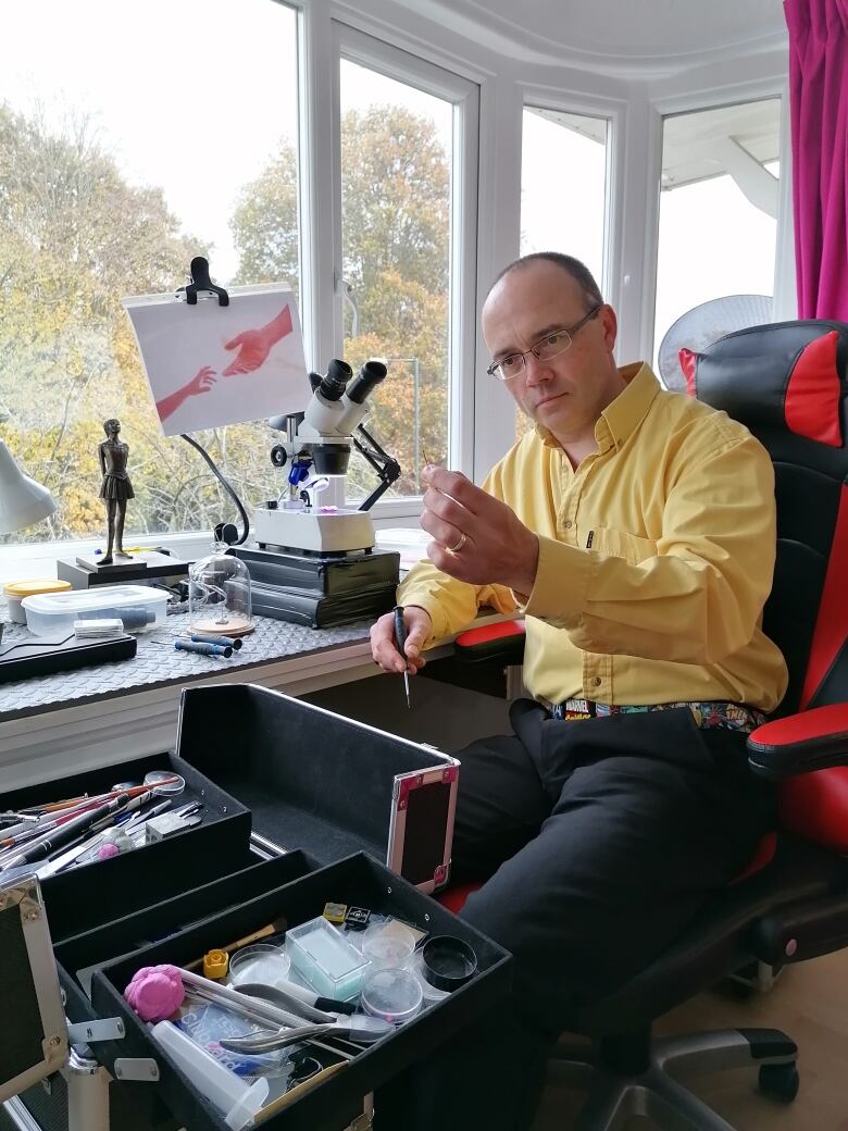 A man sitting at a microscope. 