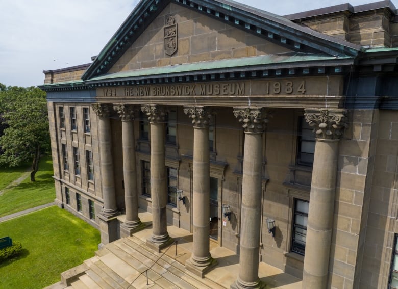 Sandstone building with giant pillars in front. 