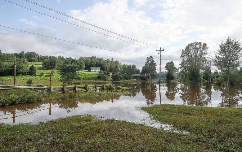 A small bridge in the countryside that is completely flooded.