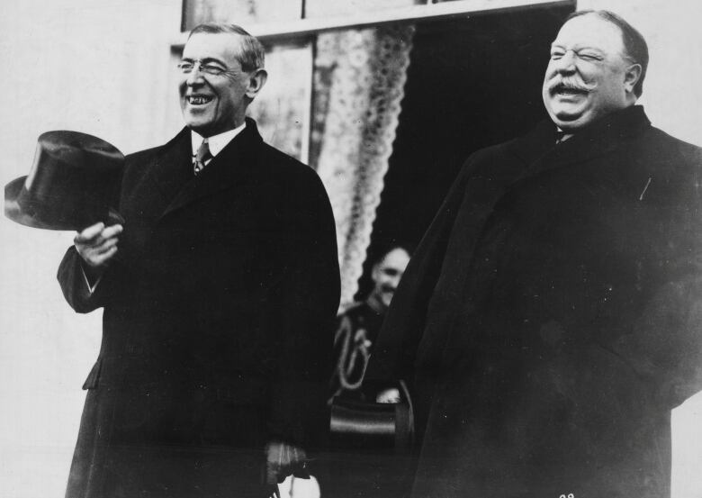 Black and white photo of two men standing and smiling