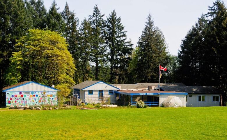 An elementary school with three small buildings and a sign reading 