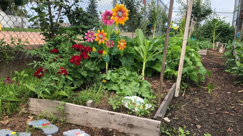 A garden bed of flowers and vegetables.