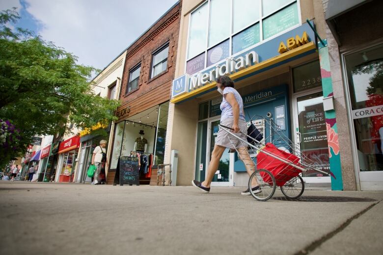 A woman walks in front of a Meridian Credit Union branch in Toronto.