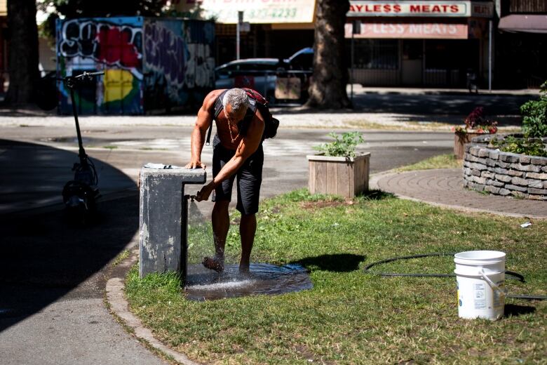 A man uses a water fountain.