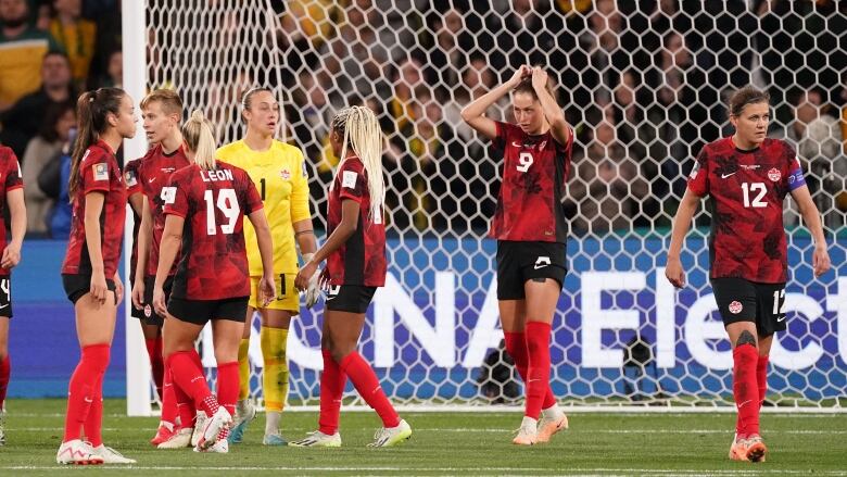 Women soccer players react after a goal.