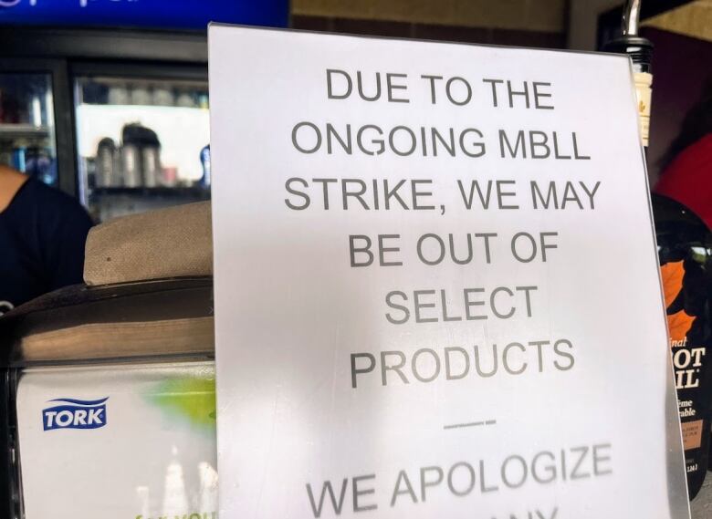 A closeup of a sign says that, due to the ongoing liquor and lotteries strike, some products might not be available.