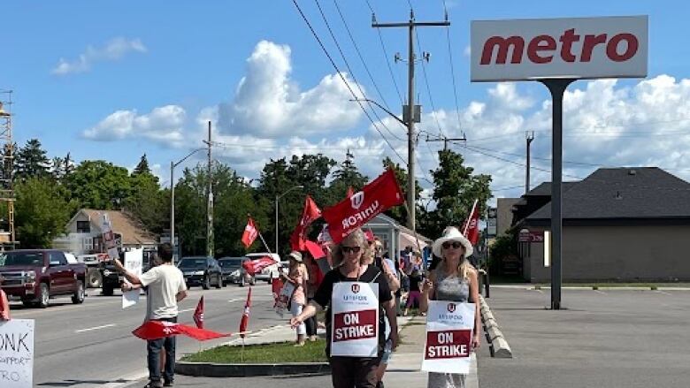 People with signs outside a Metro grocery store