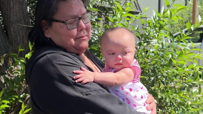 A woman holds a baby.