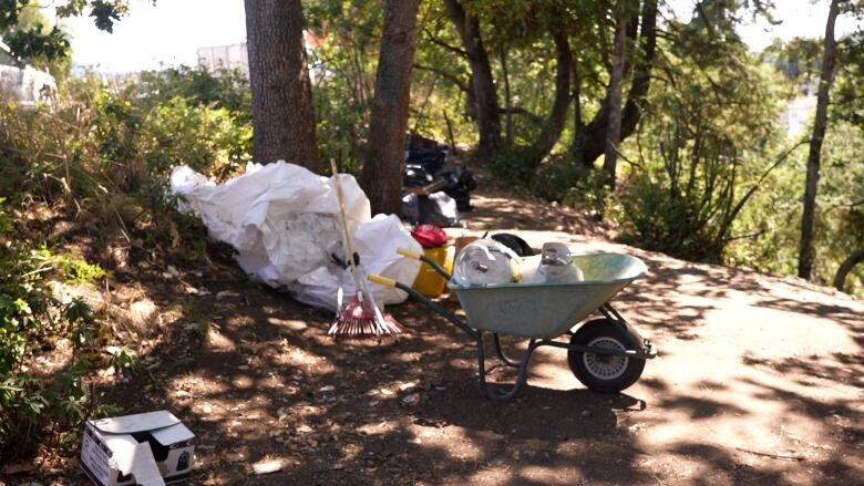 A wheelbarrow with propane tanks, and several garbage bags that were retrieved from the encampment site. 