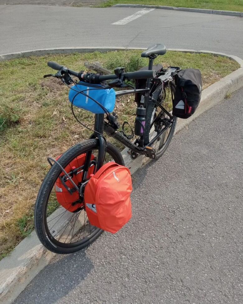 A bike with bags and other luggage on a street.