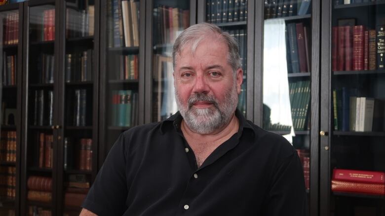 Photo of a man in a black polo shirt.