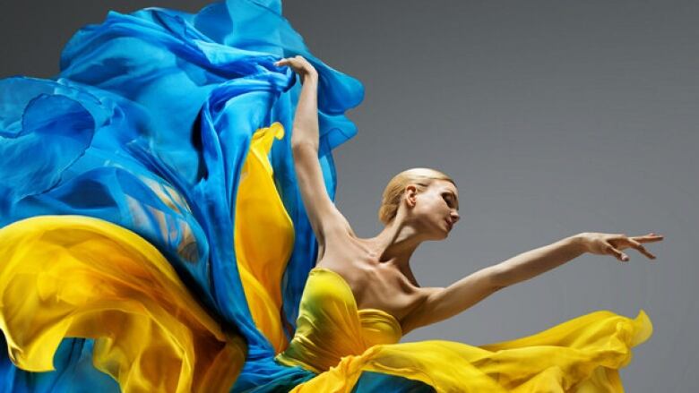 Ballerina in flowing yellow and blue garment.