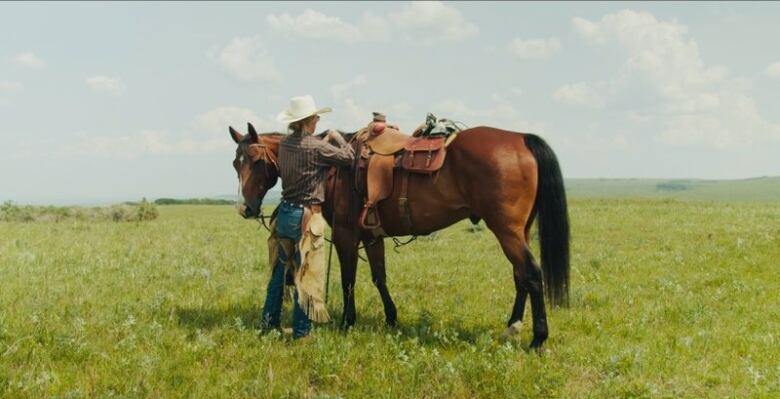 Rachel Herbert stands beside her horse, Jet on a field near Nanton, Alta.