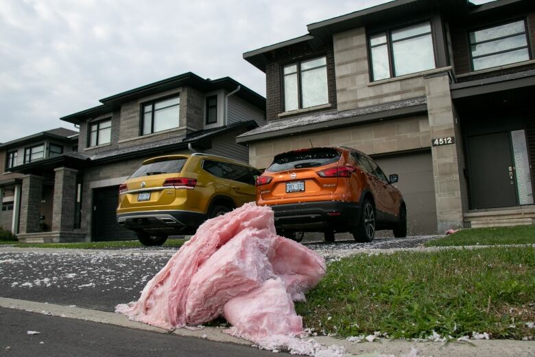 Pink insulation on the driveway of a home.